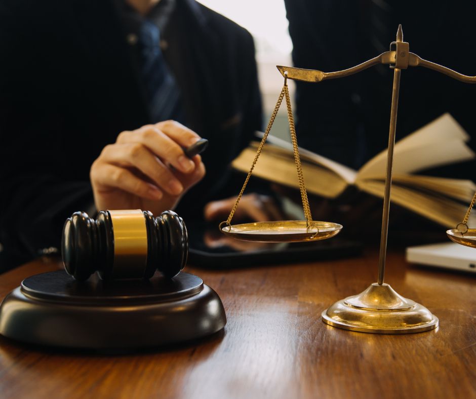 A legal setting featuring a judge's gavel, scales of justice, and an attorney reviewing documents, symbolizing legal proceedings and financial compensation. This image represents class action settlements, the average class action lawsuit payout per person, and the average settlement for a class action lawsuit, emphasizing legal rights and potential compensation for affected individuals.