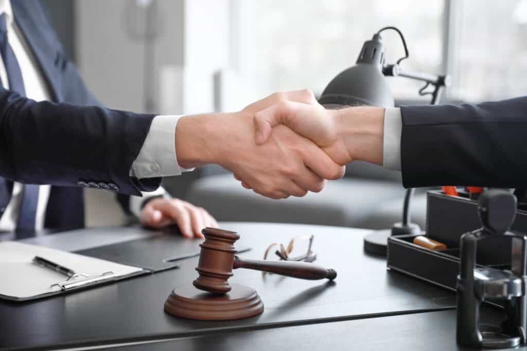 male lawyer with client shaking hands in his office for consultation