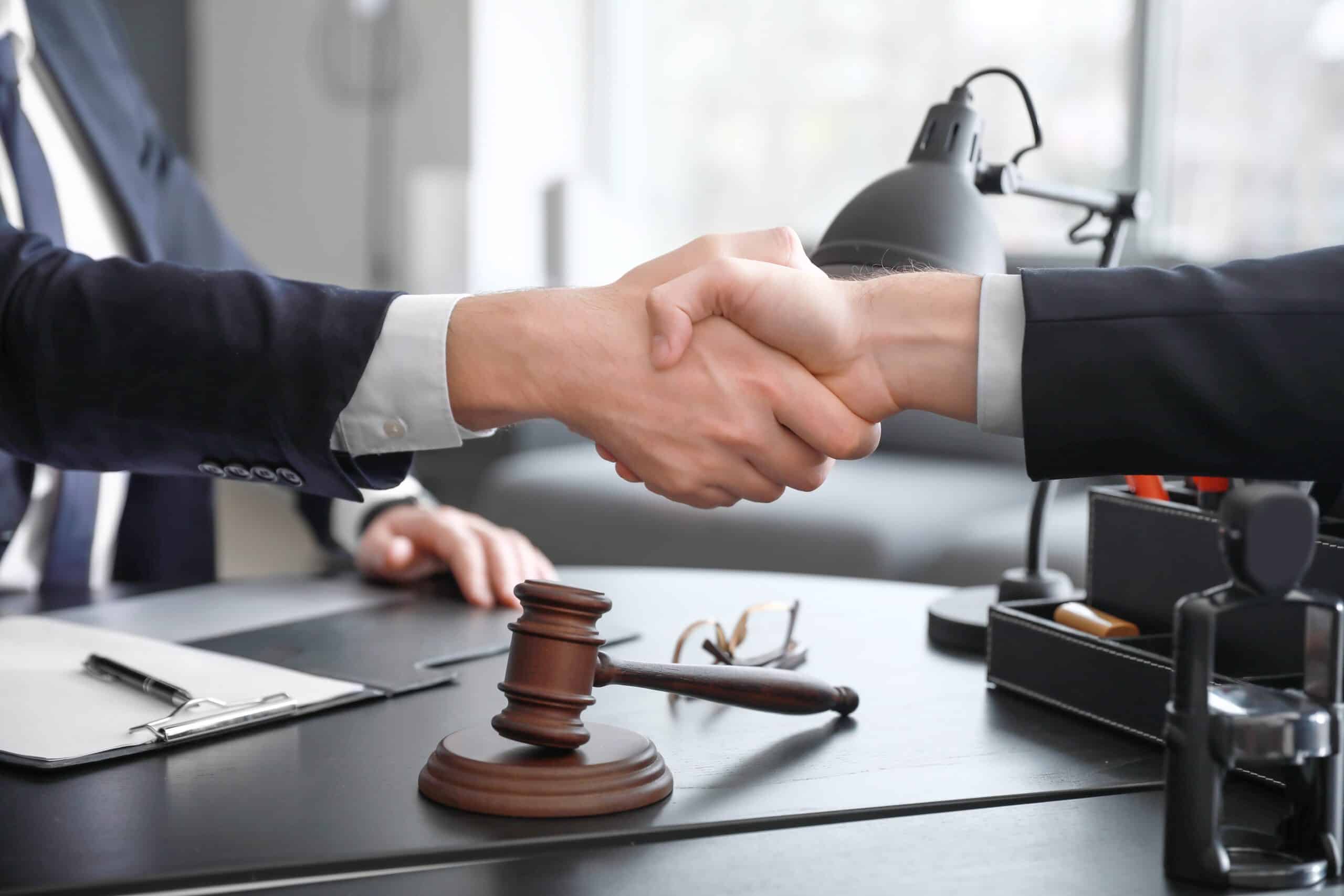 male lawyer with client shaking hands office scaled