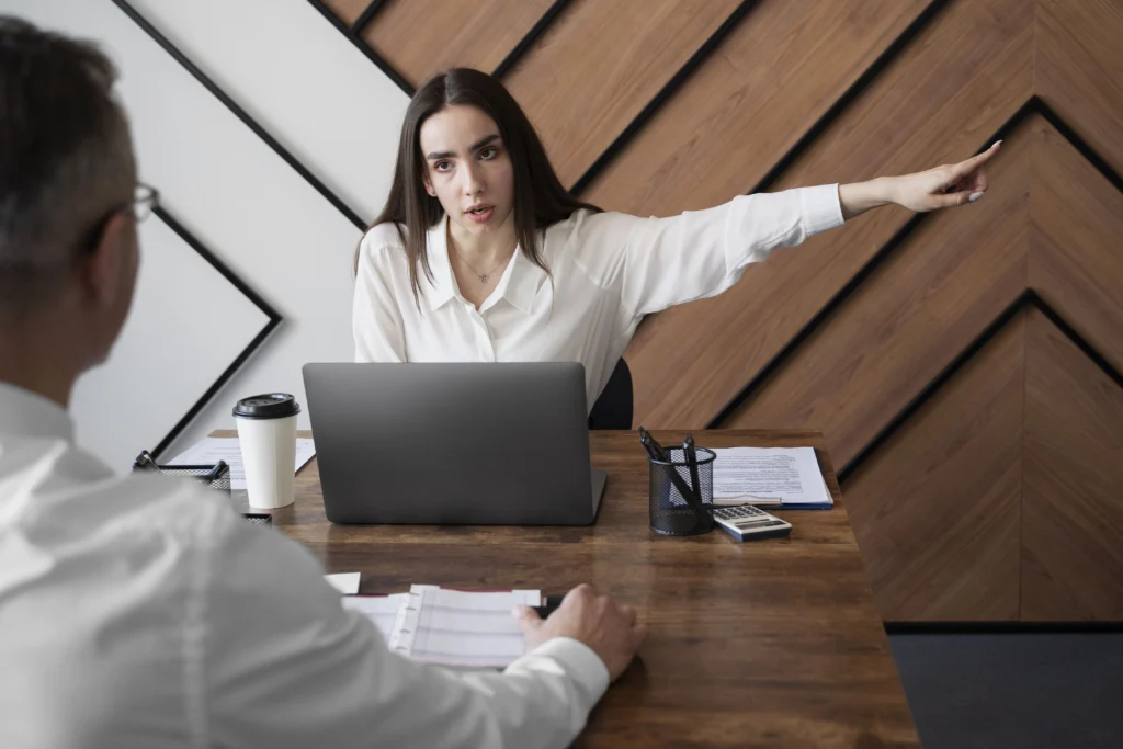 a female HR angrilky pointing out the door to her employee. wrongful termination lawyer