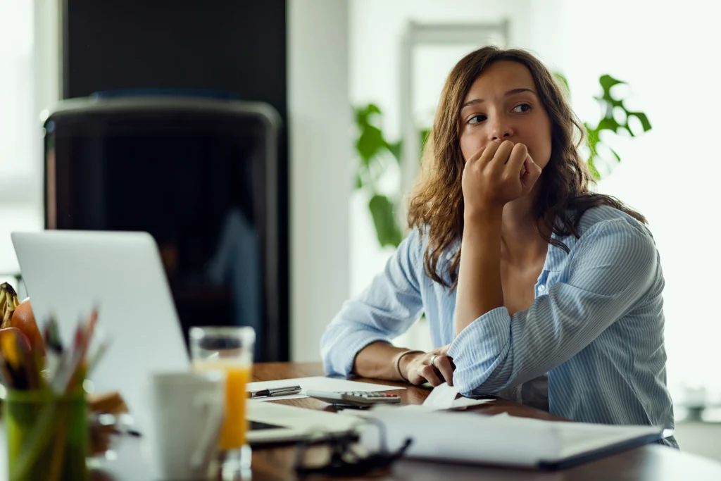 Employee looking worried while reviewing paperwork at home, representing concerns about filing a California labor board complaint under PERB AB 288.