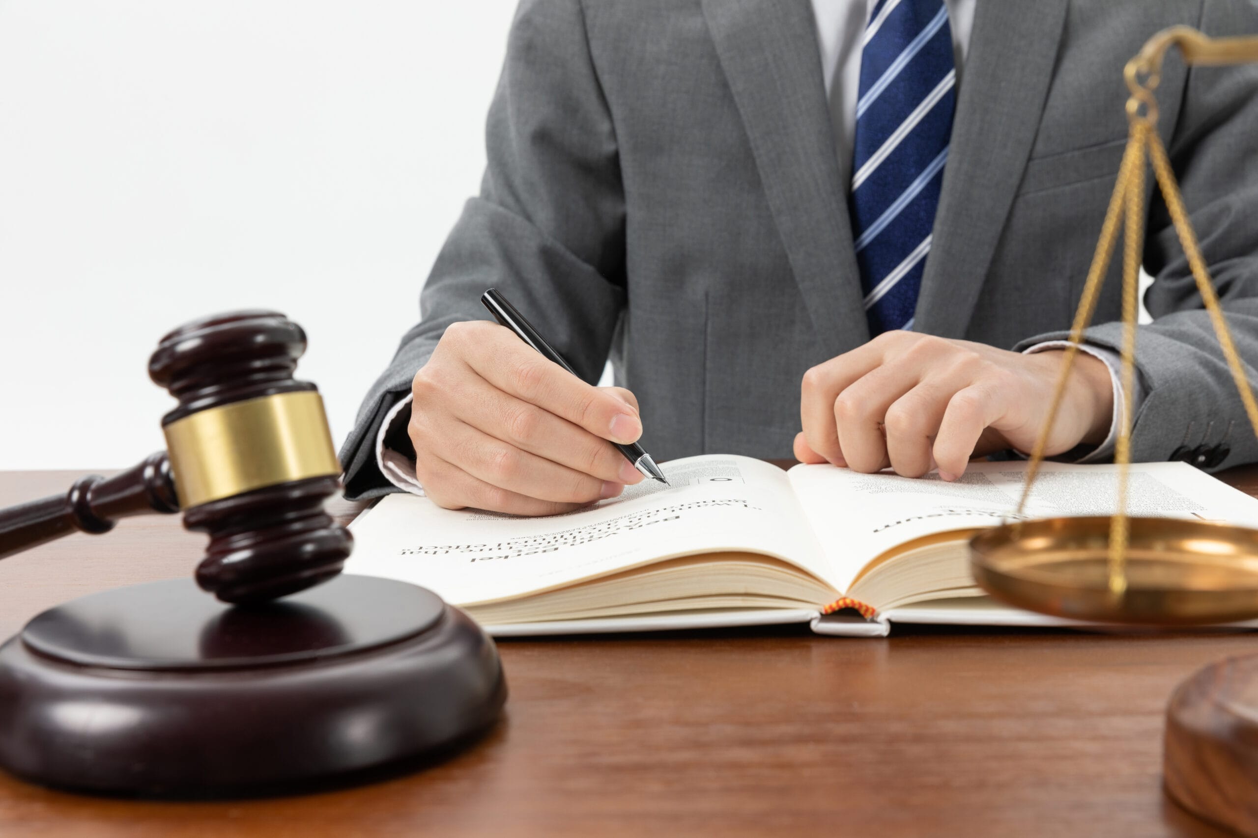 closeup shot person writing book with gavel table