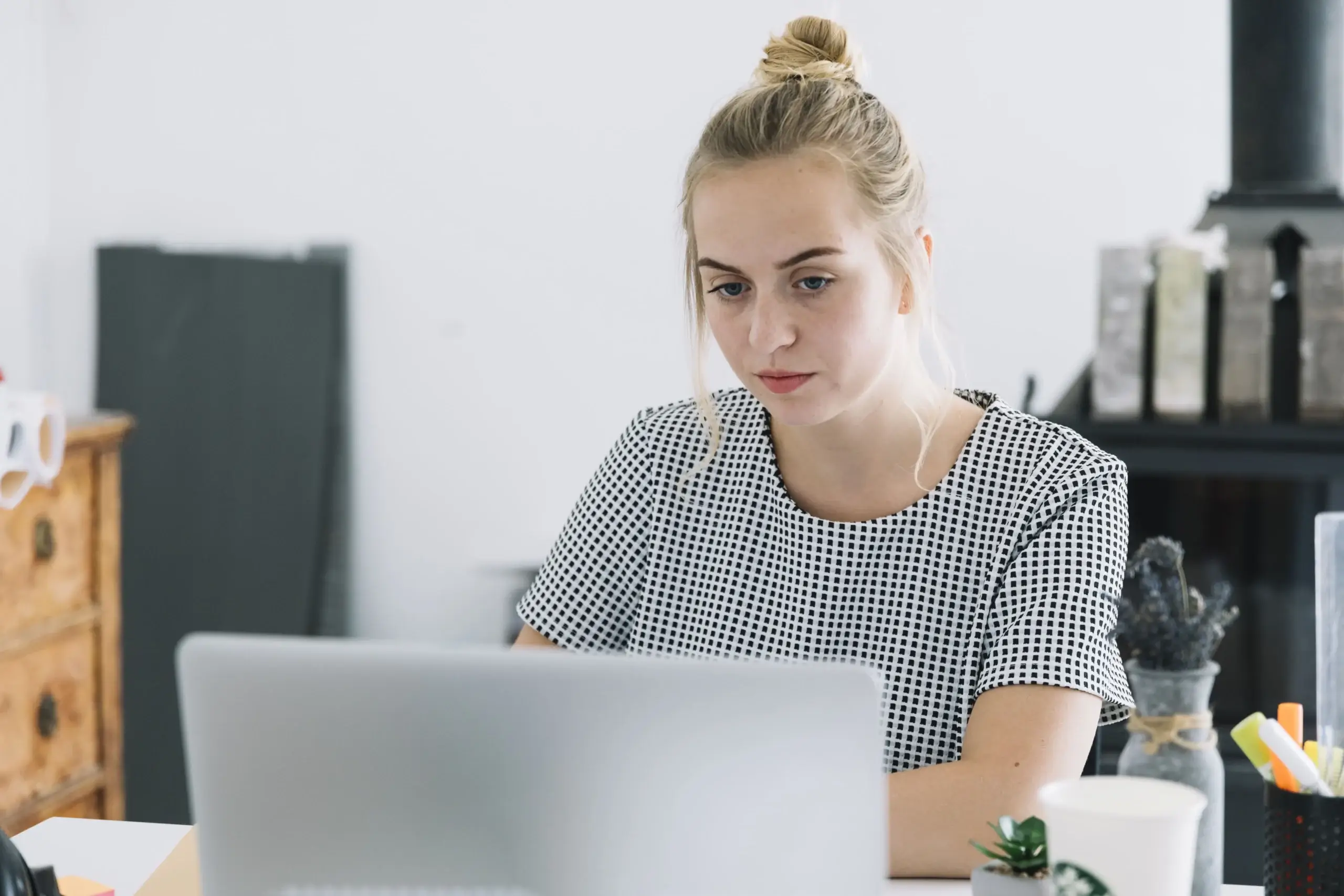 A woman sitting at a desk with a laptop, focused on her work related to California employment law deadlines